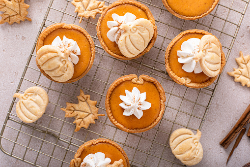 Mini pumpkin pies with with pumpkin and fall leaves decoration for Thanksgiving