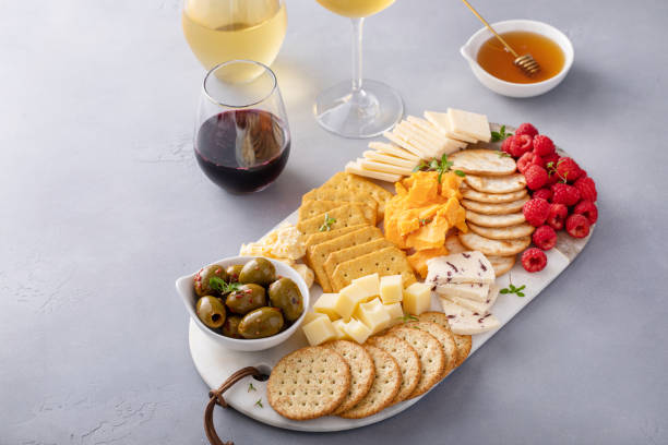 istock Cheese board or snack board with crackers, cheese, olives and berries 1641096346