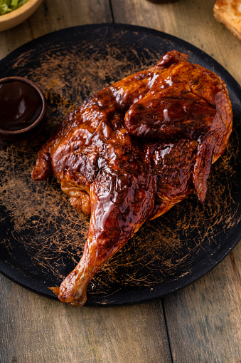 Barbeque smoked half chicken served with bbq sauce, salad and toast