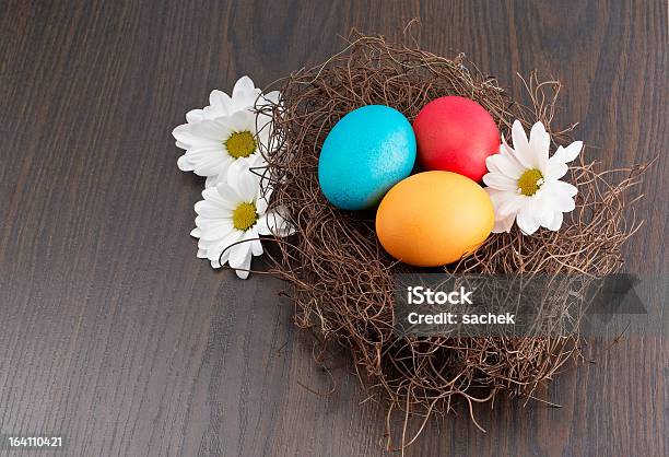 Photo libre de droit de Nid Avec Oeufs De Pâques Colorés Et Fleurs banque d'images et plus d'images libres de droit de Aliment - Aliment, Beauté de la nature, Blanc