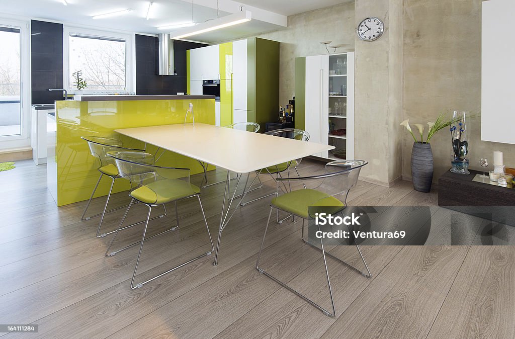 Modern kitchen interior in green and white combination Detail of modern kitchen with built-in appliance and dinner table Apartment Stock Photo