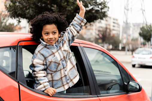 Portrait of a cute African American little boy sitting in a car