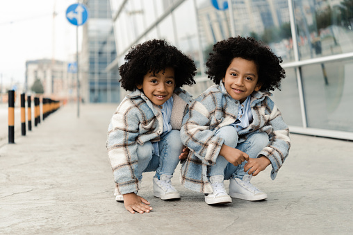 Portrait of the two cute African American twin boys playing outdoors