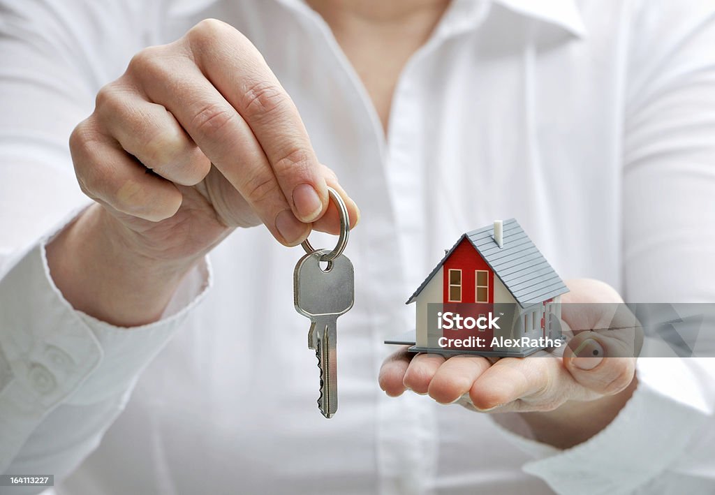 House and keys Real estate agent with house model and keys Business Stock Photo