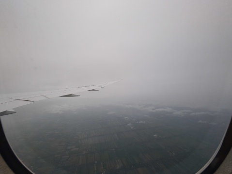 Airplane window on a cloudy day