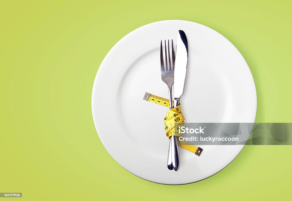 Measuring tape on a fork and knife  - dieting concept Measuring tape on a fork and knife  - dieting concept image Centimeter Stock Photo