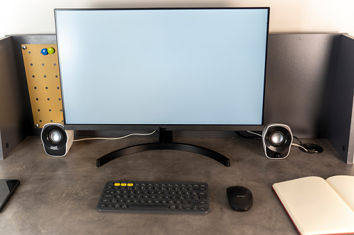 Businessman working behind a desk. White screen computer monitor.