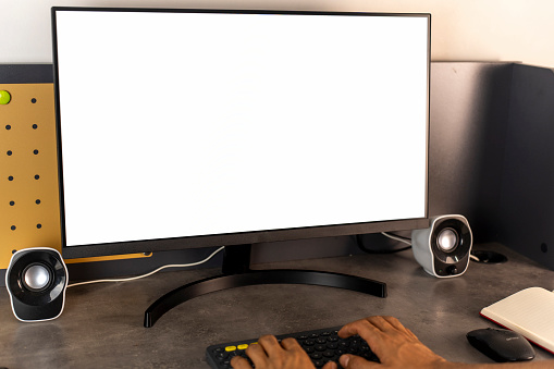 Businessman working behind a desk. White screen computer monitor.
