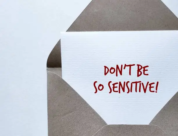 Craft envelope with handwritten message on copy space background Don't Be So Sensitive, means gaslighting or to accuse or emotional abuse others to question your beliefs and perception of reality