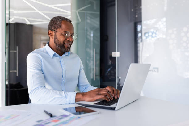 istock Successful african american businessman working inside office with laptop, man smiling and happy with achievement result at workplace 1641233763