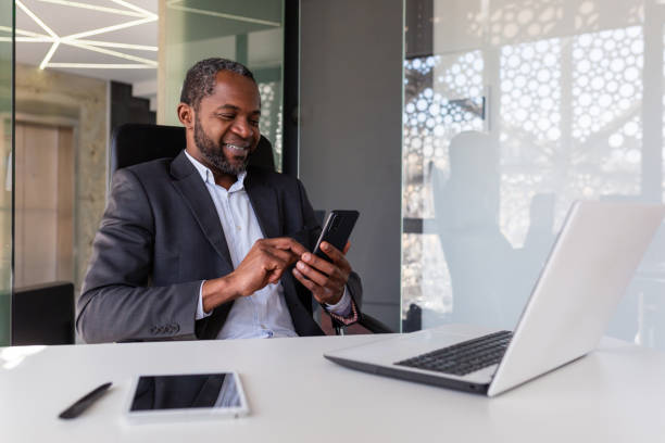 istock Mature experienced and successful african american boss at workplace inside office, senior satisfied with results businessman using phone, reading news from online app on smartphone 1641234839