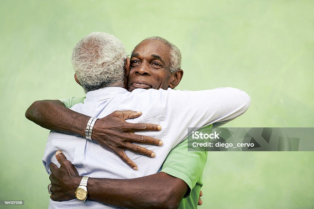 Old friends, two senior african american men meeting and hugging Active retired old men and leisure, two senior black brothers hugging outdoors Senior Adult Stock Photo