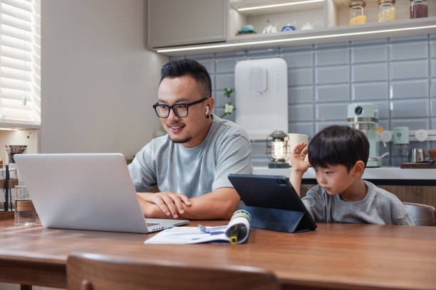 istock chian father works at the dining table, son plays by the side 1641283592