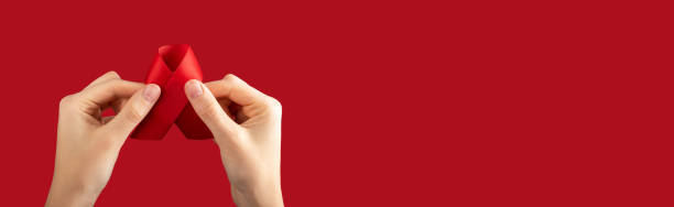 istock HIV red ribbon in hands on ad banner, background with copy space for text 1641296358