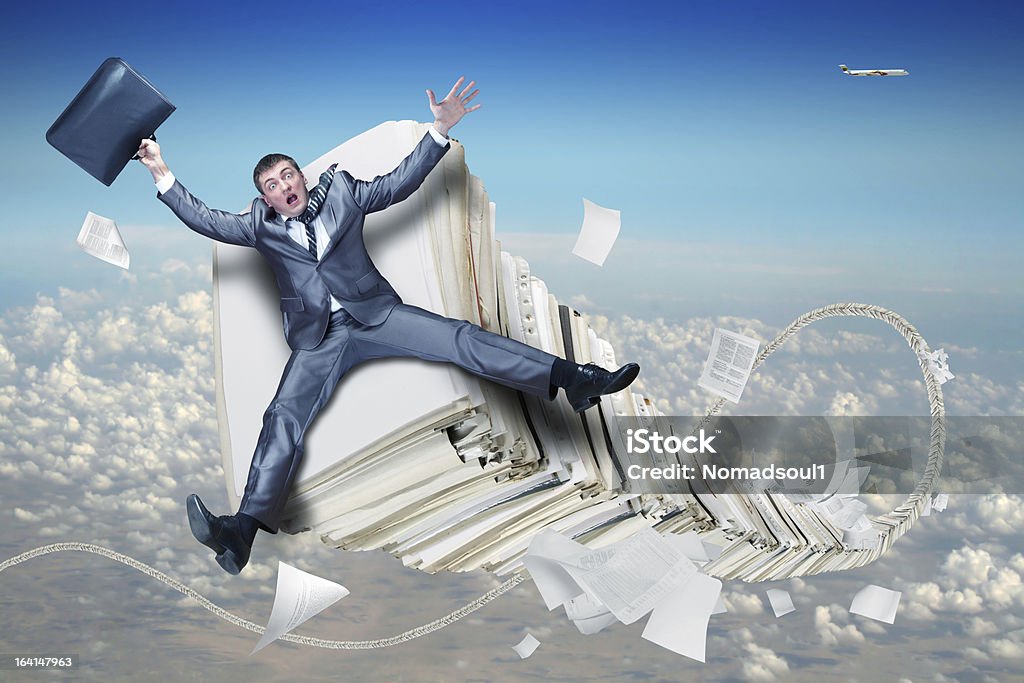 Businessman on stack of paperwork Scared businessman on huge stack of paperwork File Folder Stock Photo