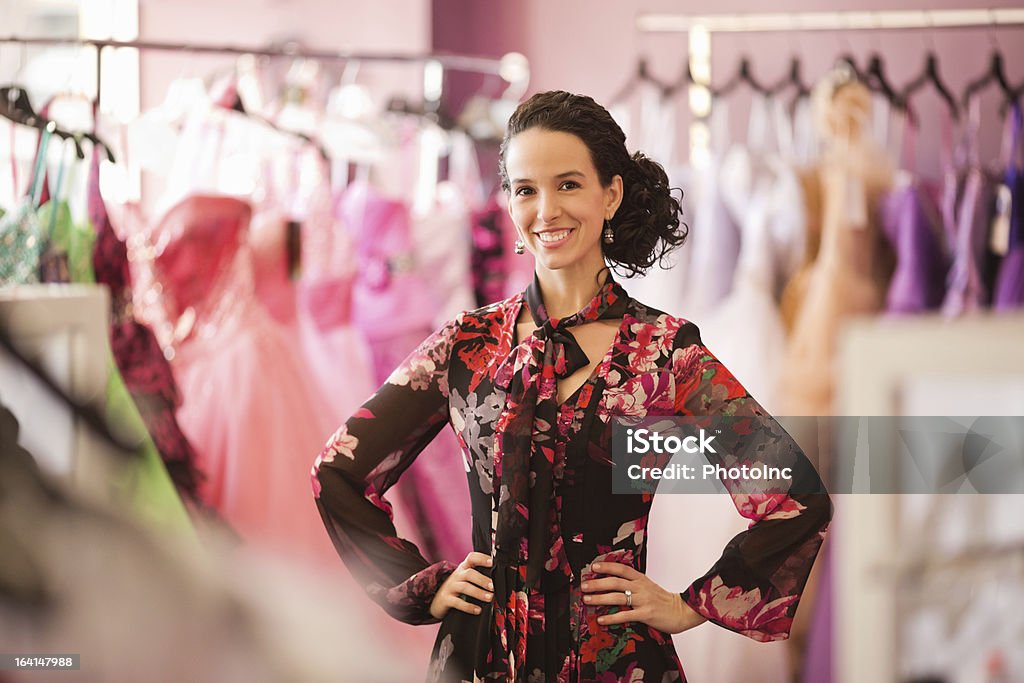 Proprietário da loja em pé com uma mão no quadril - Foto de stock de Butique royalty-free