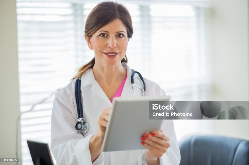 Heureuse femme médecin avec Tablette numérique - Photo de 40-44 ans libre de droits