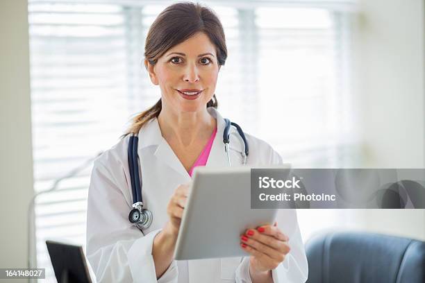 Foto de Feliz Feminino Médico Com Tablet Digital e mais fotos de stock de 40-44 anos - 40-44 anos, Adulto, Adulto maduro