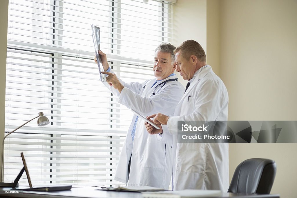 Arzt mit digitalen Tablet untersuchen X-Ray Bericht In Clinic - Lizenzfrei Arbeiten Stock-Foto