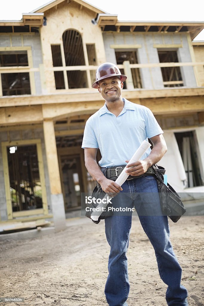 Arquiteto masculino com Blueprint em pé na frente de incompleta Ho - Foto de stock de Na Frente De royalty-free