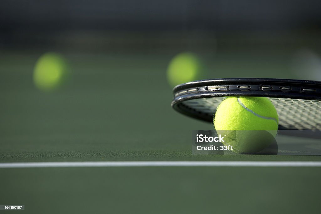 Tennis Ball and Racket Tennis Ball and Racket with more balls off in the distance Competition Stock Photo