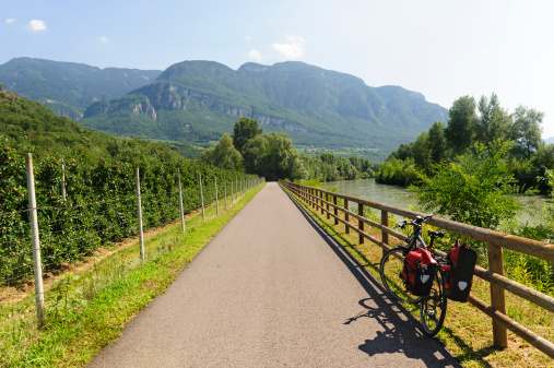 Cycle lane of the Adige valley near Bolzano (Trentino Alto Adige, Italy) at summer and bicycle with bags