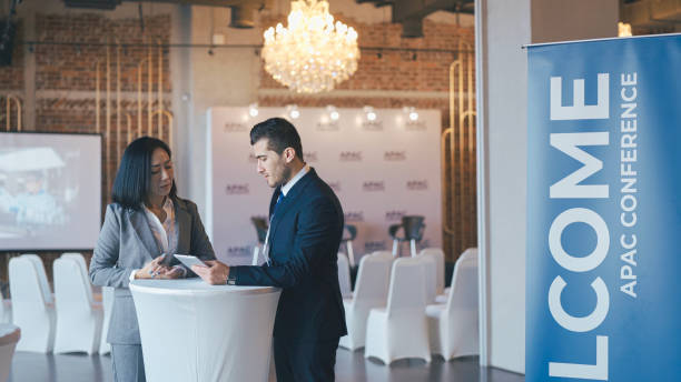istock Asian Chinese businesswoman final check going through programme details with banquet hall manager before the business conference seminar begin 1641611842