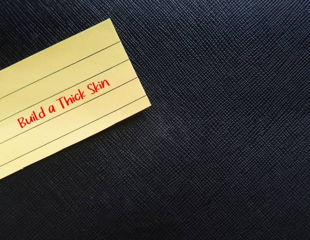 istock Black copy space PU artificial leather background with yellow note written BUILD A THICK SKIN, self reminder to stop being too sensitive, refuse to get overly responsive to negative comments of others 1641620374