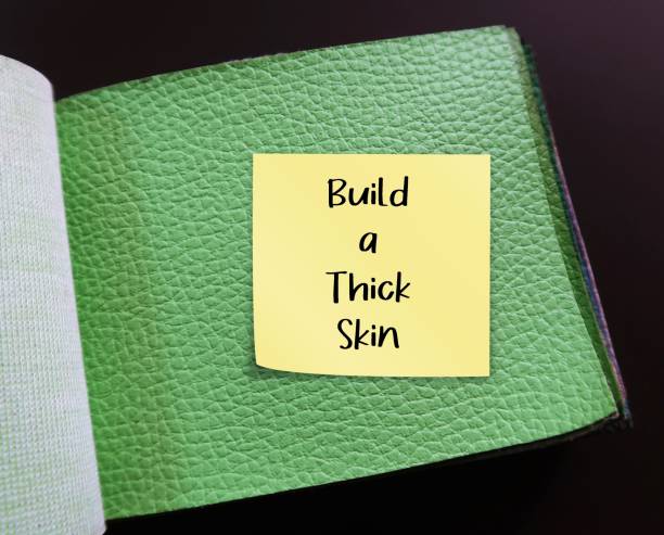 istock Green articicial PU leather sample with stick note written BUILD A THICK SKIN, self reminder to stop being too sensitive, refuse to get overly responsive to negative comments of others 1641620827
