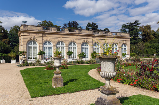 Boulogne-Billancourt, France - August 13 2023: Orangerie in the Bagatelle park with the rose garden in the foreground. It was built in 1835. It is located in Boulogne-Billancourt near Paris, France