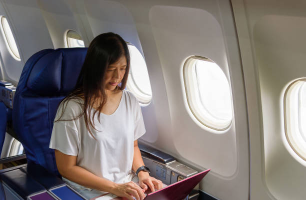 istock Asian business woman commercial plane passenger using laptop on board for working while sitting in airplane. Traveling and technology image concept. 1641636803
