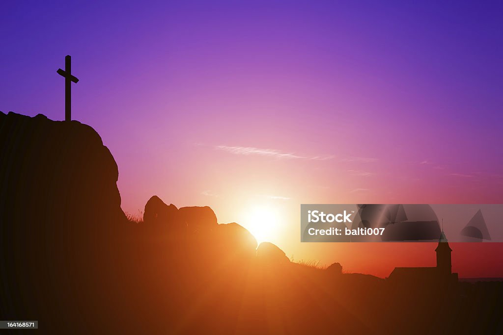 Cross, Church and Sunrise Single cross and church on a rocky hilltop at sunrise. Purple Stock Photo