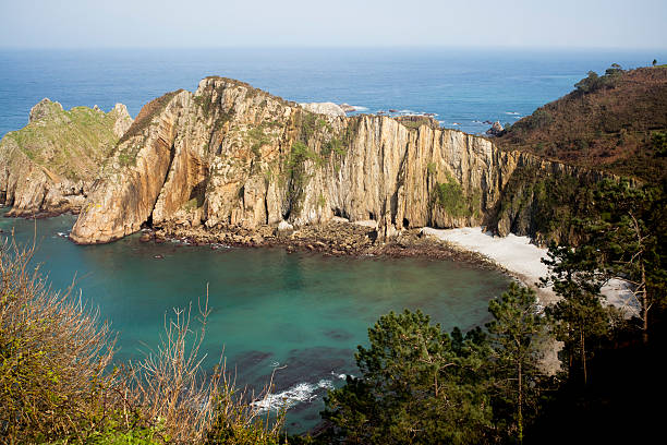 Cliff, beach and pines in playa del Silencio (silence beach). Asturias, Spain.