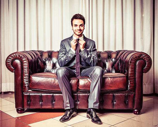 Happy businessman on a leather sofa.