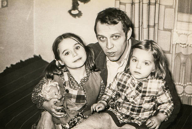 Vintage photo of father with daughters Poland, early eighties sister photos stock pictures, royalty-free photos & images