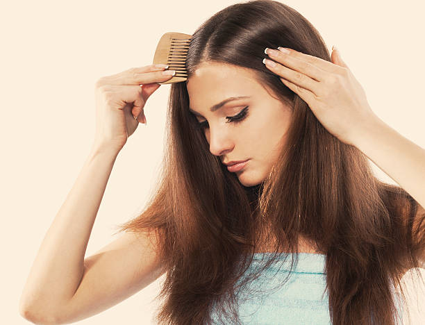 young lady oscuras su hermoso cabello largo peinar - hair care combing women human hair fotografías e imágenes de stock