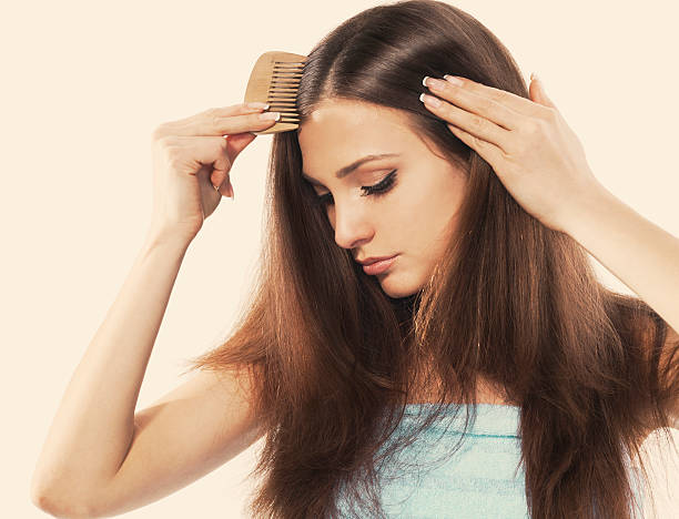 A young woman with beautiful long hair combing her locks Young brunette lady combing her beautiful long hair. isolated white combing photos stock pictures, royalty-free photos & images