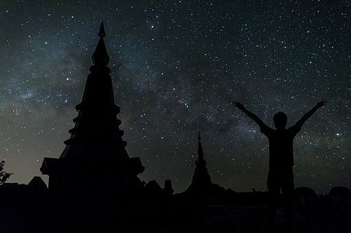 Man happy seeing Milky way over the two pagodas, the landmark of Doi Inthanon at Chiang Mai, Thailand.