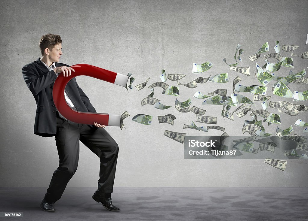 Businessman attracts lots of money with a giant magnet Businessman attracts money with a large magnet Currency Stock Photo