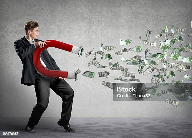 Businessman Attracts Lots Of Money With A Giant Magnet Stock Photo - Download Image Now