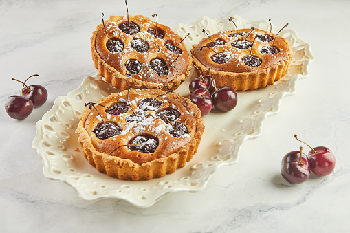 French Flair, Cherry Clafoutis Presented on White Marble. Mouthwatering Temptation: Clafoutis and Cherries on Marble.