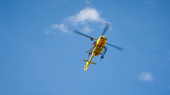 Wiesbaden, Germany - July 10, 2021: German rescue helicopter Christoph 77 of ADAC air rescue service is taking off from the scene in a recreational park in the city center of Wiesbaden, Germany
