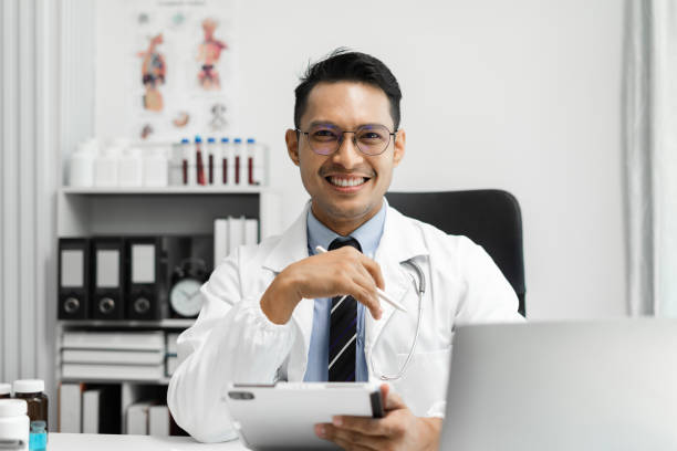 istock Male doctor sitting at a desk, looking at the camera. 1641891002