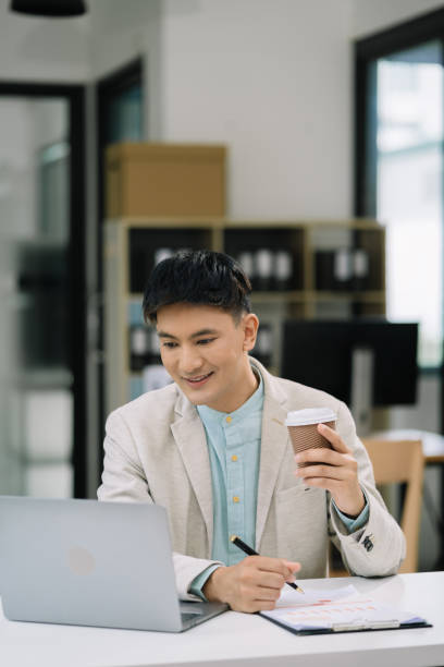 istock Businessman using laptop computer in office. Happy man, entrepreneur, small business owner working online. 1641892090