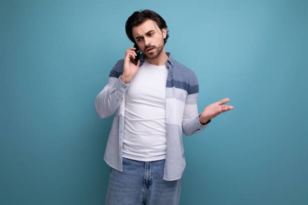 istock nice brunette guy in casual style chatting on the phone 1641894183