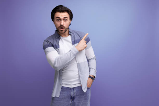 istock nice brunette guy in casual style shows with his hand for having an idea on a studio background 1641894184