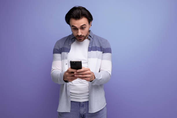 istock brutal brunette guy in casual style communicates using smartphone 1641894193