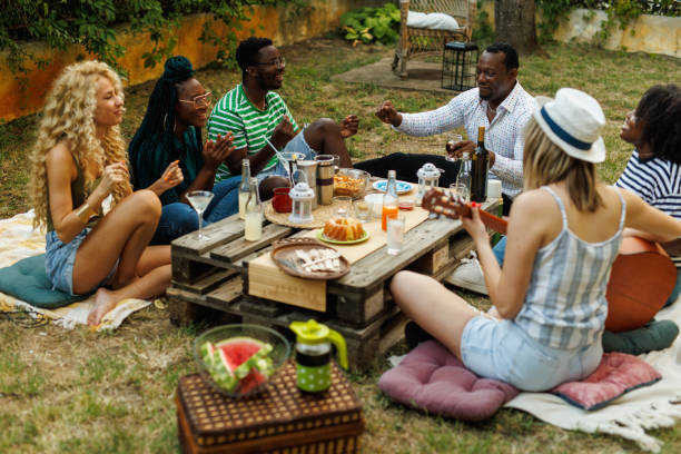 istock Friends hanging out, enjoying drinks and snacks during a picnic 1641903401