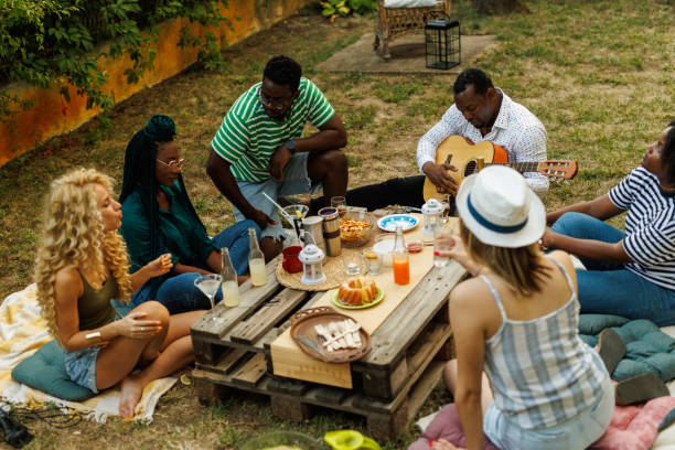 istock Friends hanging out, enjoying drinks and snacks during a picnic 1641903408