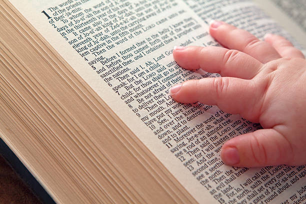 bebé de la mano en la biblia abierta - kjv fotografías e imágenes de stock